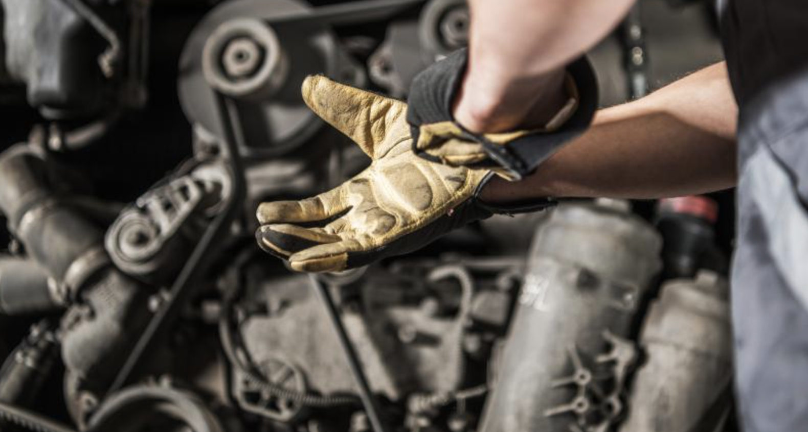 Gloved hands in front of diesel engine