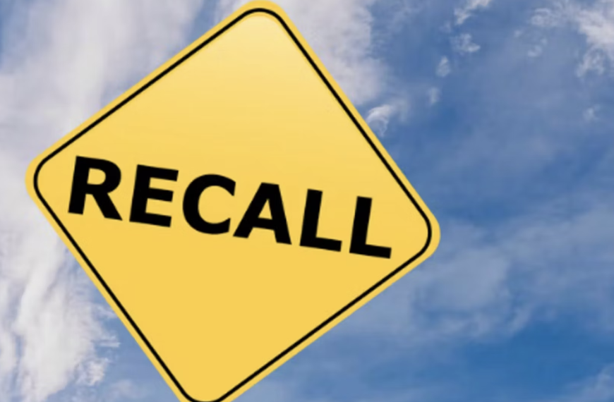 "Recall" on yellow highway sign against blue sky