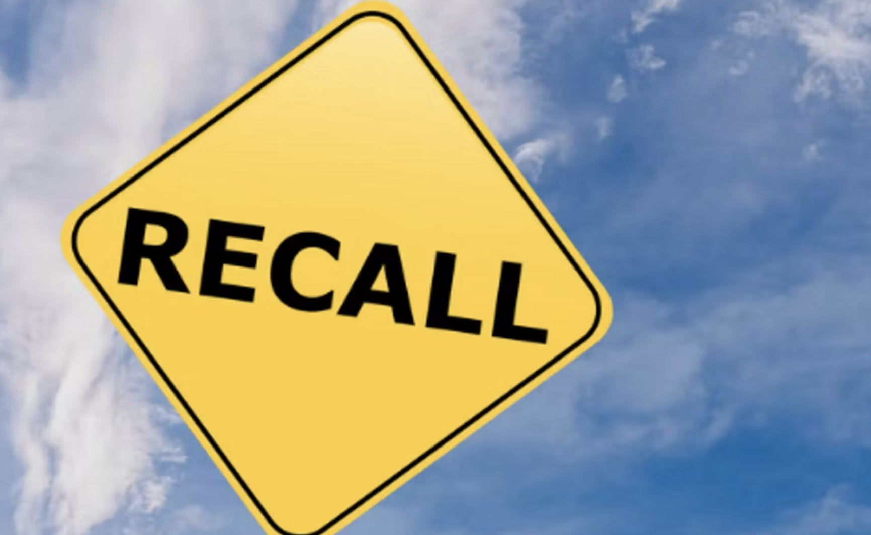 "Recall" on yellow highway sign against blue sky